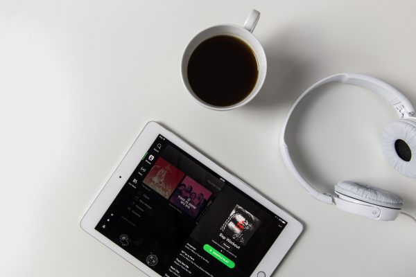 Spotify on an iPad with coffee and headphones