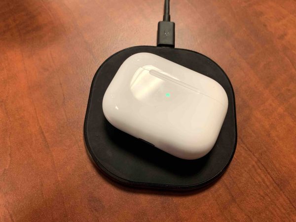 An AirPods Pro case charging on a charging mat