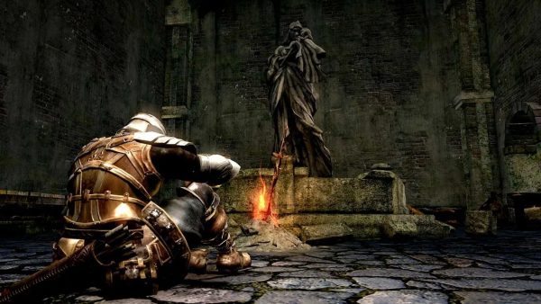 Image of the Dark Souls main character resting in front of a campfire.