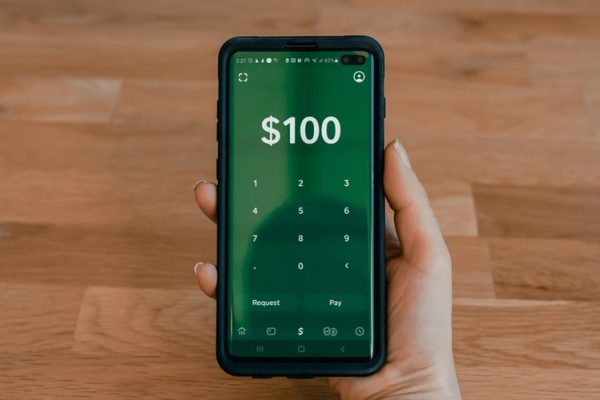 person holding a black smartphone with the Cash App app openrtpho