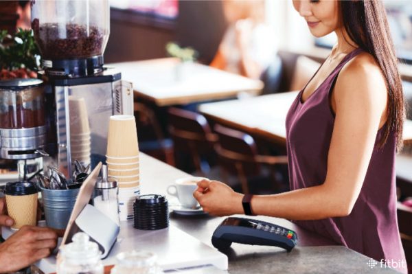 A person using Fitbit Pay to pay at a terminal