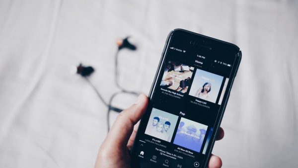 A person holding a smartphone with the Spotify app open