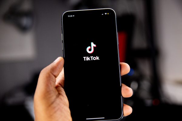 A person holding a smartphone with the TikTok app open